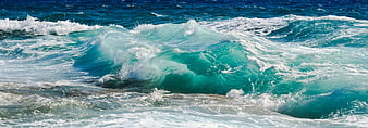 Powerful turquoise ocean wave crashing with white foam