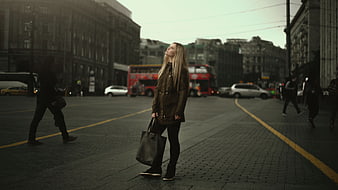 Blonde woman in leather jacket standing on London street