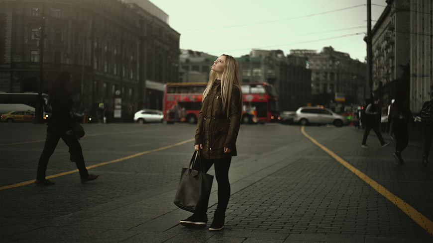 Blonde woman in leather jacket standing on London street