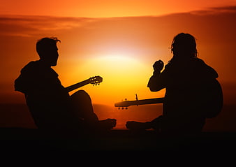 Silhouette of Two Guitarists Playing at Sunset