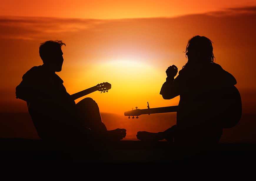 Silhouette of Two Guitarists Playing at Sunset