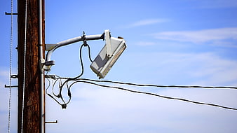 Wooden Utility Pole With Electrical Wires And Equipment Against Blue Sky