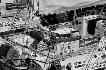 Sailor steering racing yacht in black and white