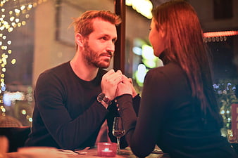 Romantic couple holding hands at candlelit restaurant dinner