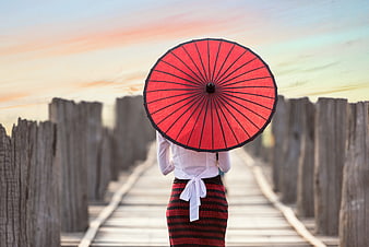 Woman with Red Parasol Walking on Wooden Bridge