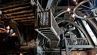 Dark rustic wooden staircase interior with spiral stairs and beams
