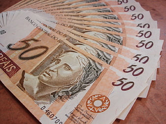Fan of Brazilian 50 Real banknotes on wooden surface