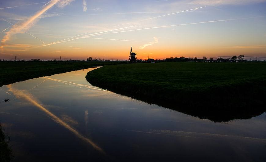 Dutch Windmill Silhouette at Sunset Over Canal