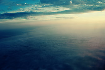 Aerial View of Clouds at Sunset from Airplane Window