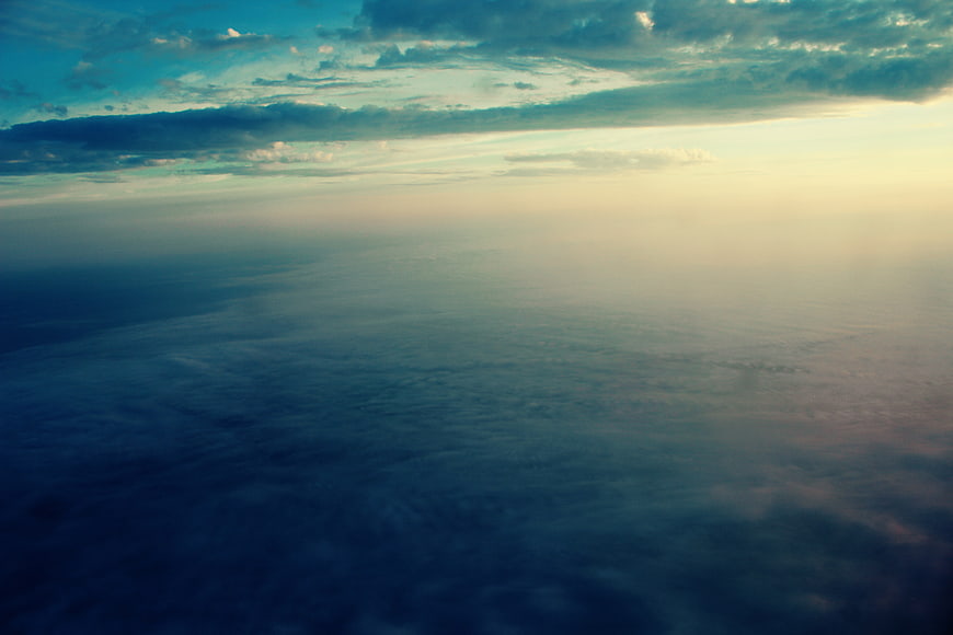 Aerial View of Clouds at Sunset from Airplane Window