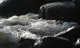 Rushing River Water Flowing Over Dark Rocks