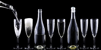 Champagne pouring into flutes on black background