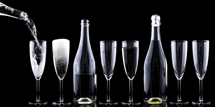 Champagne pouring into flutes on black background