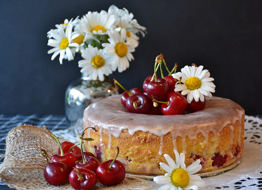 Homemade Cherry Cake With Glaze And Daisies On Rustic Table