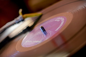 Close-up of spinning pink vinyl record on turntable