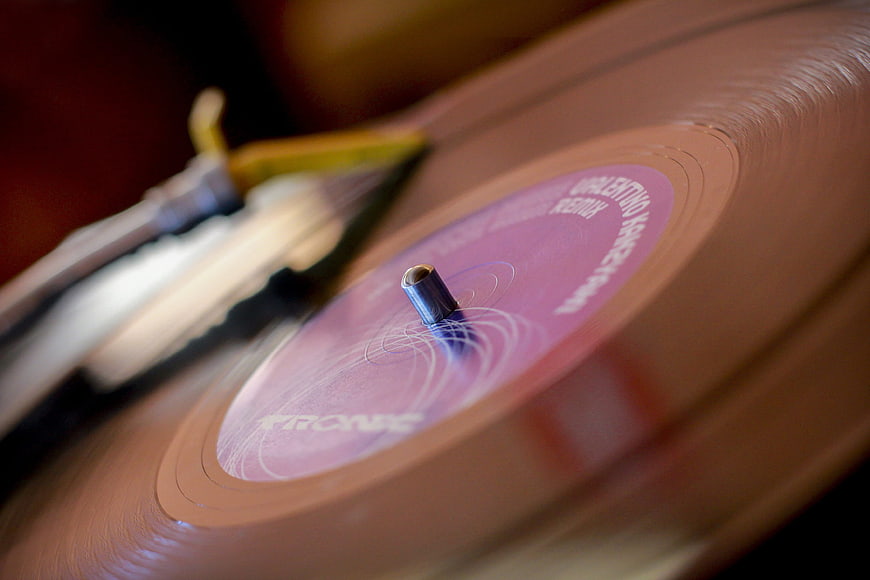 Close-up of spinning pink vinyl record on turntable