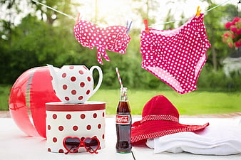 Summer poolside accessories with pink polka dot swimsuit and Coca-Cola