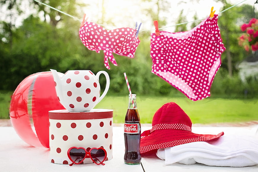 Summer poolside accessories with pink polka dot swimsuit and Coca-Cola