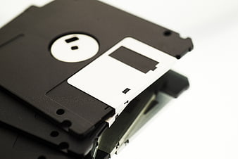 Stack of vintage black floppy disks on white background