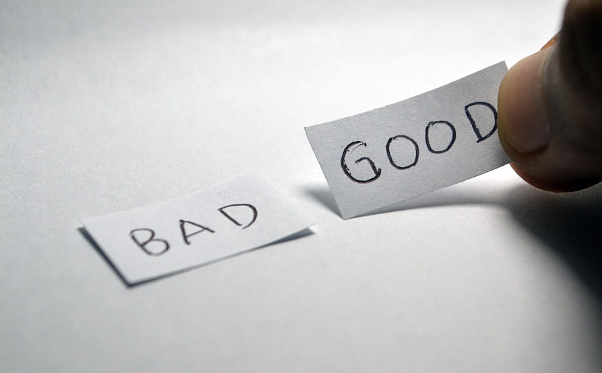 Hand choosing good over bad paper note