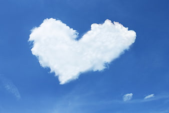 Heart-shaped white cloud in blue sky