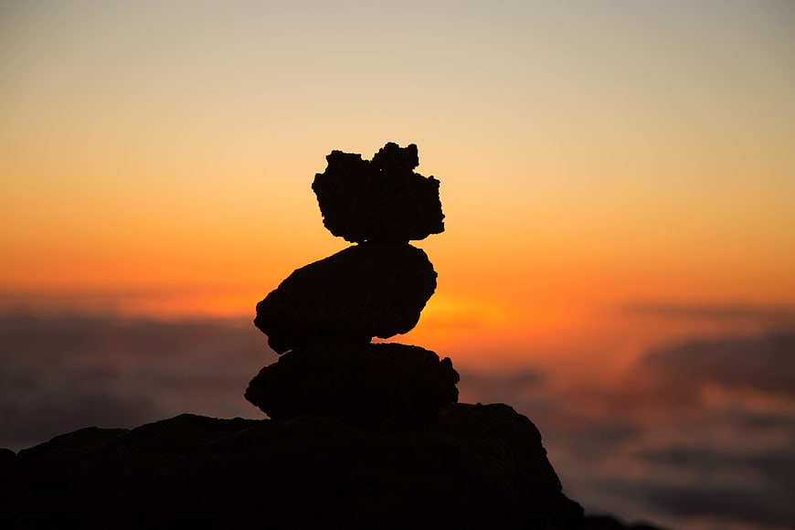 Silhouette of Balanced Rock Stack Against Orange Sunset Sky
