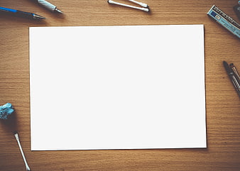 Blank white paper on wooden desk with art supplies