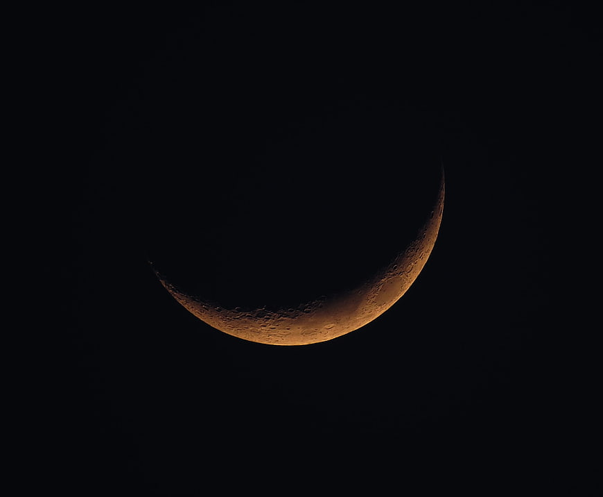Crescent Moon with Craters in Dark Night Sky