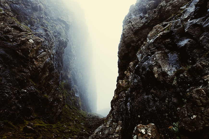 Misty Mountain Gorge with Mossy Rocks and Foggy Sky