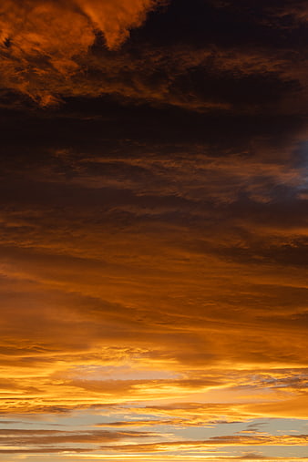 Dramatic fiery orange sunset clouds in the sky