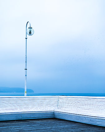 Minimalist White Bench and Lamp Post on Coastal Pier