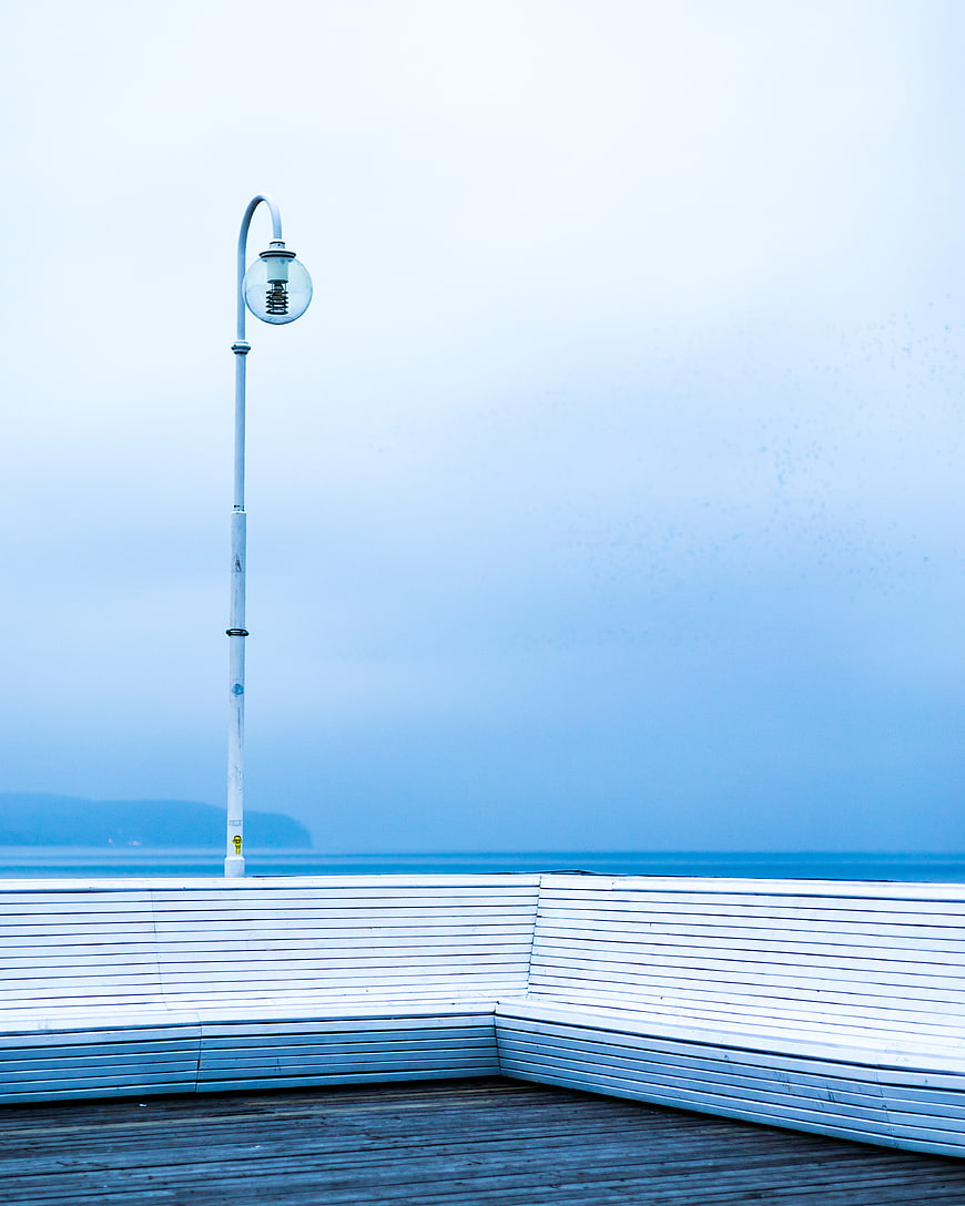 Minimalist White Bench and Lamp Post on Coastal Pier