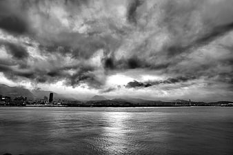 Dramatic Black and White Cityscape Under Stormy Clouds