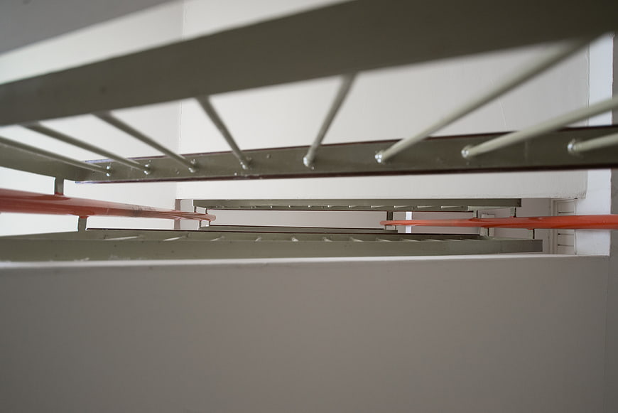 Low angle view of modern metal staircase with orange railings