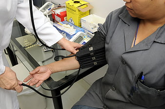 Doctor measuring patient blood pressure in clinic