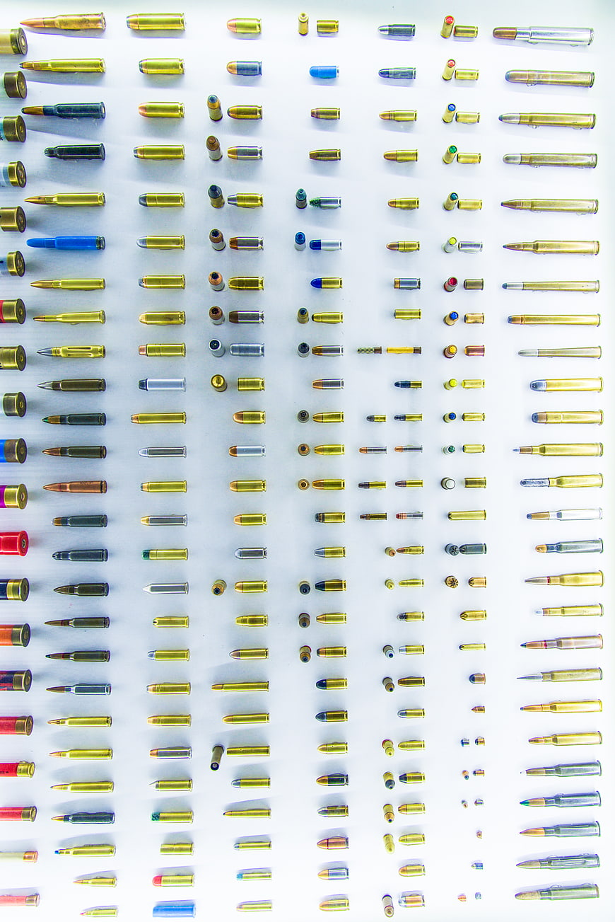 Flat lay of various ammunition cartridges on white background