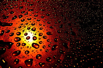 Macro water droplets on glass with warm sunset background