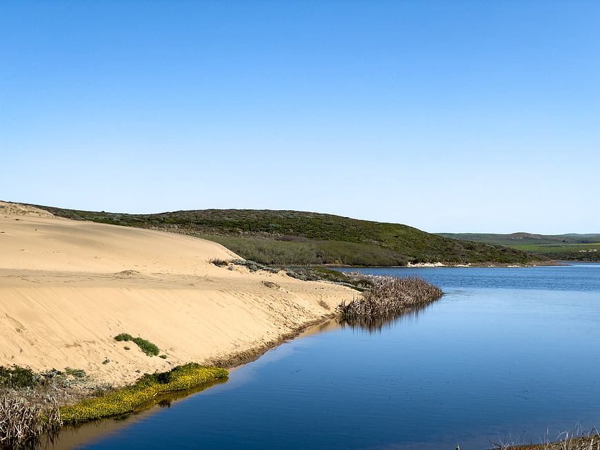 Serene river landscape with sandy dunes and blue sky