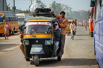Overloaded Auto Rickshaw on Busy Indian Road