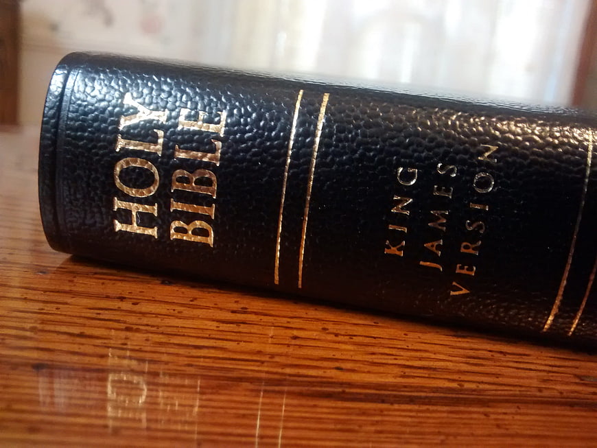 Black leather King James Version Holy Bible on wooden table