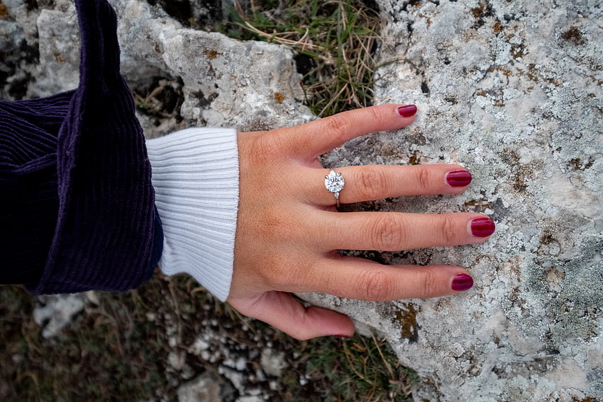 Woman's hand with diamond engagement ring on rock
