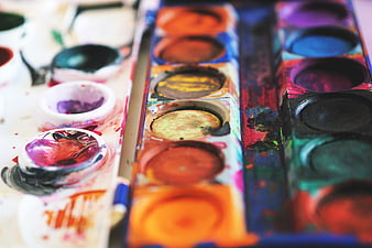 Close-up of used watercolor paint palette with vibrant colors