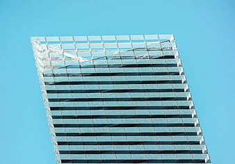 Modern glass skyscraper facade against clear blue sky