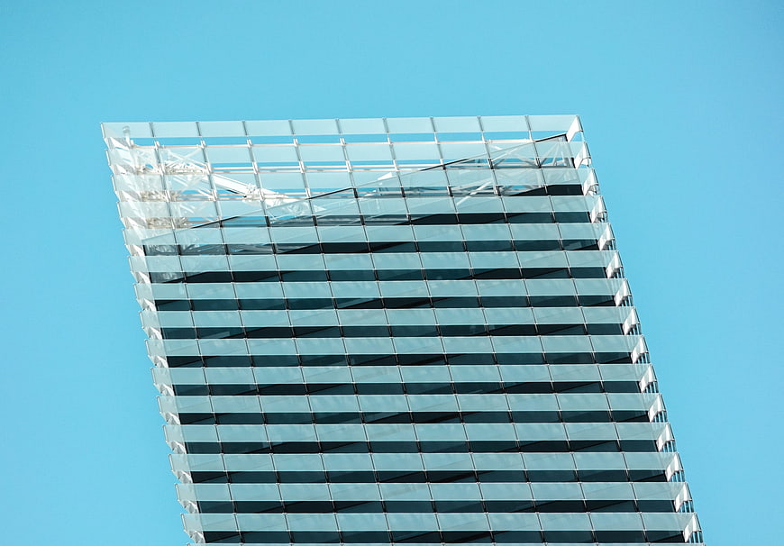 Modern glass skyscraper facade against clear blue sky