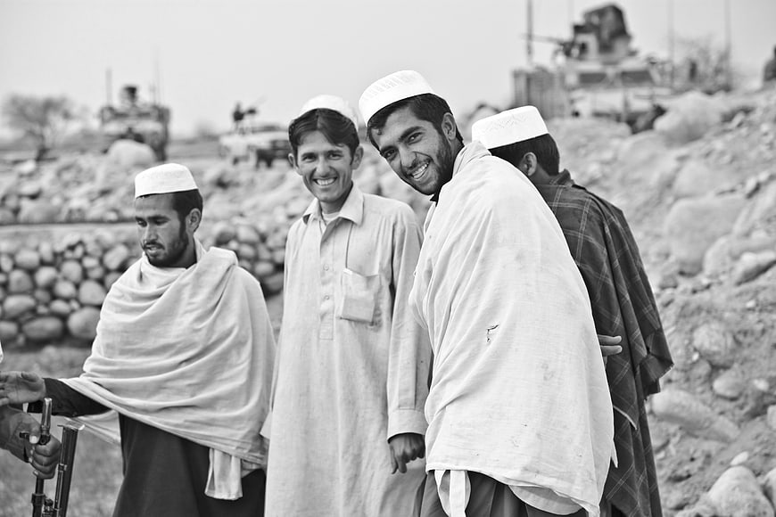 Afghan Men in Traditional Clothing Smiling in Black and White
