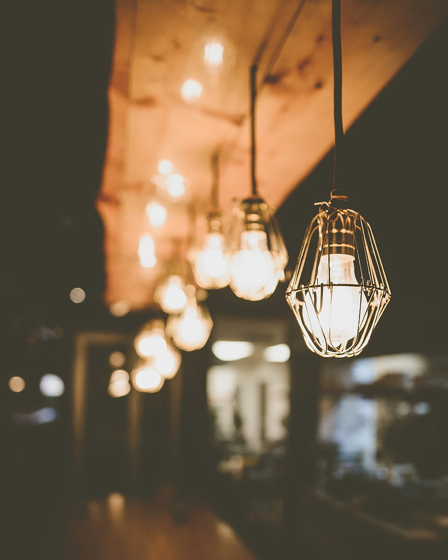 Vintage industrial pendant lights with wire cages hanging in a row