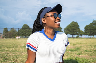 Happy Black Woman in Visor and Sunglasses in Park