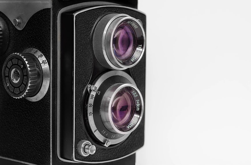 Close-up of vintage twin-lens reflex camera on white background