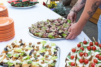 Catering table with roast beef, cheese, and tomato appetizers