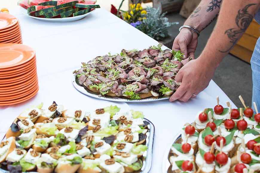 Catering table with roast beef, cheese, and tomato appetizers